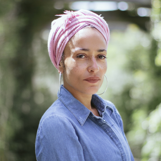 Forfatterportræt af Zadie Smith, der står foran et træ.