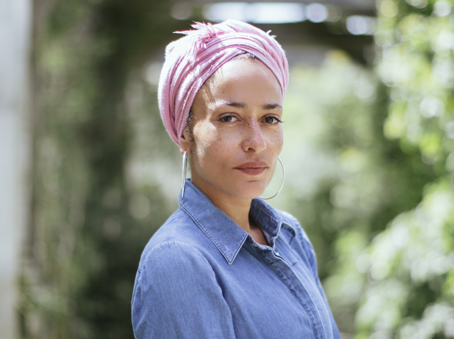 Forfatterportræt af Zadie Smith, der står foran et træ.